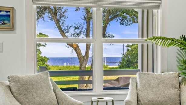 A room with two armchairs facing a large window overlooking a beach and ocean. - Scenic Sandpiper by the Shore (Long Beach)