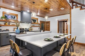 A modern kitchen with a central island, wooden ceiling, and built-in appliances. - 100% Kids & Adults LOVE this Cabin! Heated Pool, Espresso Bar, Playset, Pool Tbl (Broken Bow)