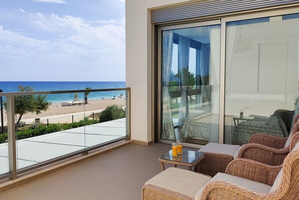 A balcony with a view of the beach and ocean.
