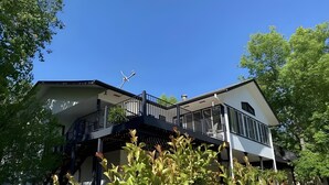 A modern two-story house with a balcony, surrounded by greenery. - Large home on the 8th fairway of the Balboa Golf Course with decks and sunroom! (Hot Springs)
