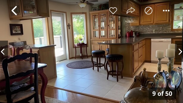 A spacious kitchen with wooden cabinets, a dining area with a table and chairs, and a view of the outdoors. - Large home on the 8th fairway of the Balboa Golf Course with decks and sunroom! (Hot Springs)