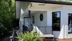 A modern house with a wooden deck, a covered porch, and a bed with a view of the garden. - Large home on the 8th fairway of the Balboa Golf Course with decks and sunroom! (Hot Springs)