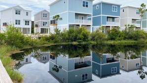 Zona residencial frente al agua con edificios de varios pisos, algunos con balcones, y una masa de agua tranquila que refleja las construcciones.