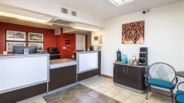 A modern reception area with a counter, seating, and artwork on the walls.