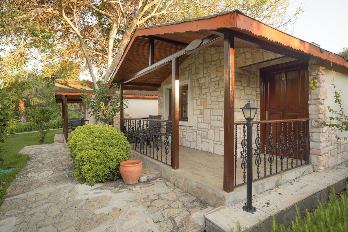 A stone building with a wooden door and a balcony with wrought iron railings.