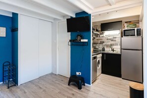 Enjoy cooking in this well-equipped kitchen with a flat-screen TV, refrigerator, microwave, and washing machine.