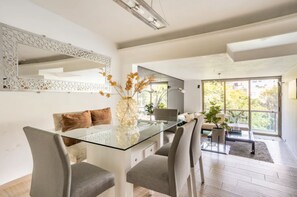 Enjoy meals in this stylish dining area with a glass table, comfortable chairs, and a beautiful view.