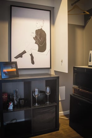 Relax in a serene space with a large artwork and a stylish shelving unit.