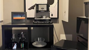 Eine Küchenzeile mit Kaffeemaschine, einer gerahmten Karte und einer Mikrowelle.
