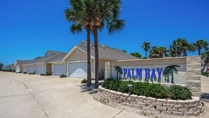 Ein Wohngebiet mit einem Schild, auf dem "PALM BAY" steht, und Häuser mit Garagentoren.