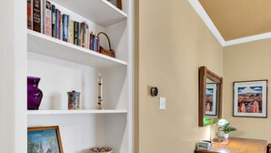 Een interieur met een boekenkast, een eettafel en een stoel.