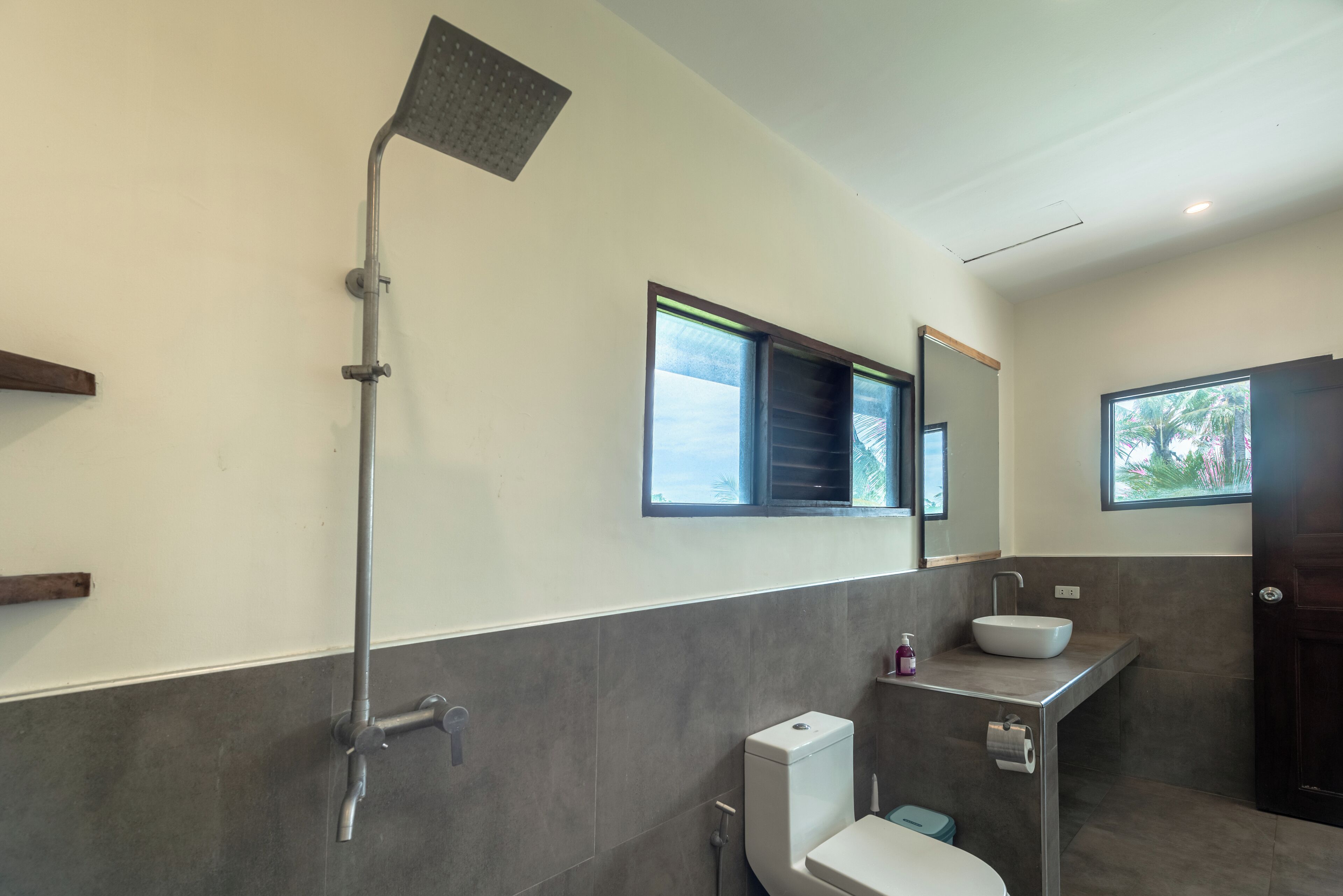 A modern bathroom with a shower, toilet, and sink.