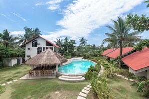 A house with a swimming pool, surrounded by lush greenery and palm trees. - Ohana Resort Siargao (General Luna)