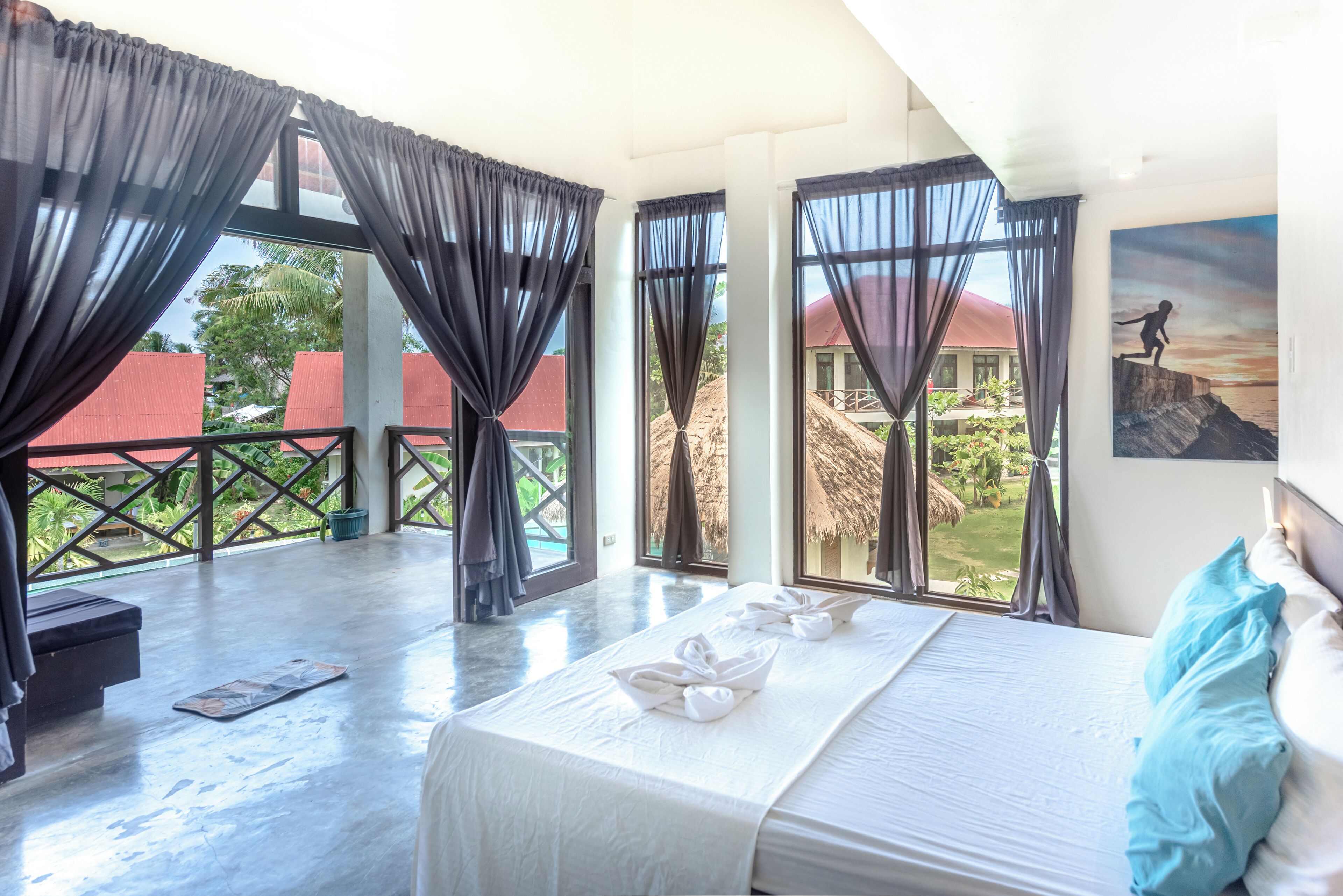 A hotel room with a large bed, a view of the outside, and a balcony.