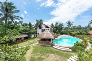 A house with a pool, surrounded by lush greenery and palm trees. - Ohana Resort Siargao (General Luna)