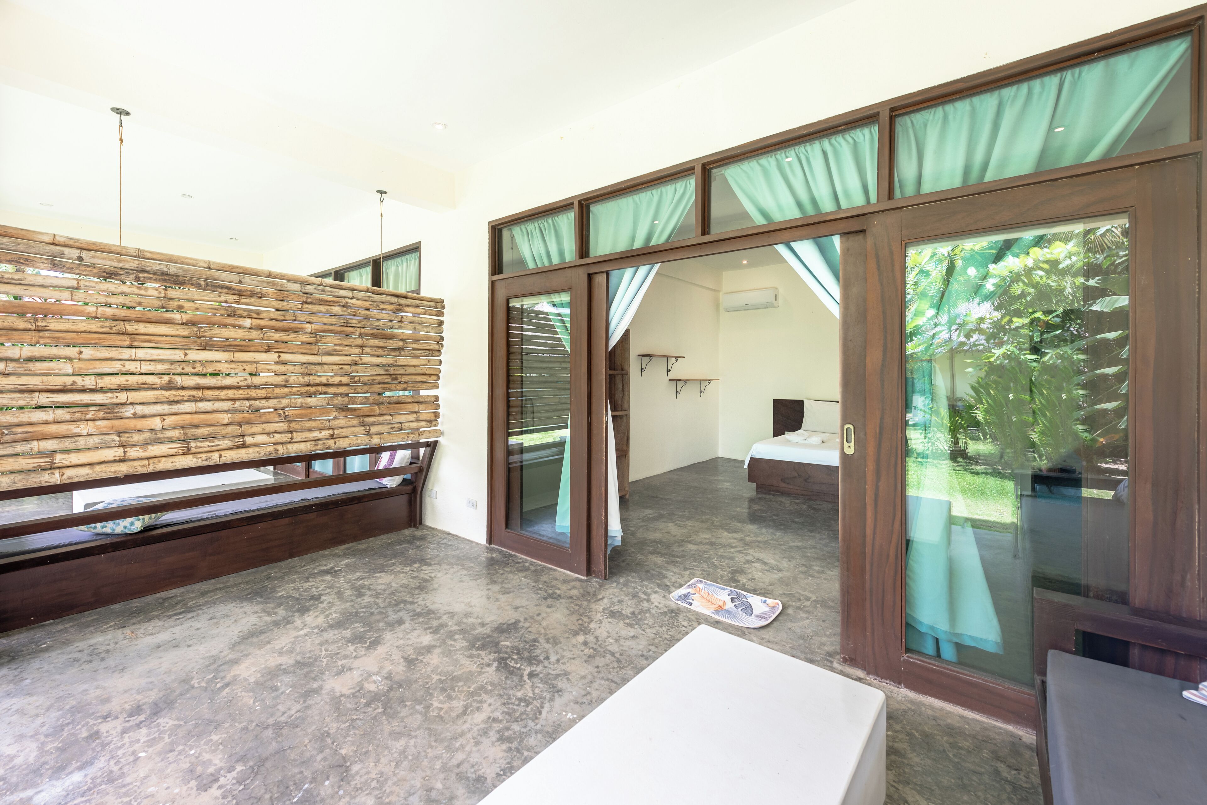 A modern room with a wooden wall, a large sliding glass door to a balcony, and a white table.