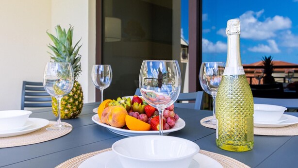 Een gedekte tafel met champagne, fruit en wijnglazen.