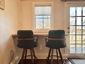 A room with a desk, two chairs, a window, and a door. - Convenient 1 BR in Center of Acadia! [Willowbrook] (Mount Desert)