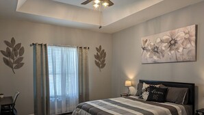 Un dormitorio con cama, escritorio y silla.