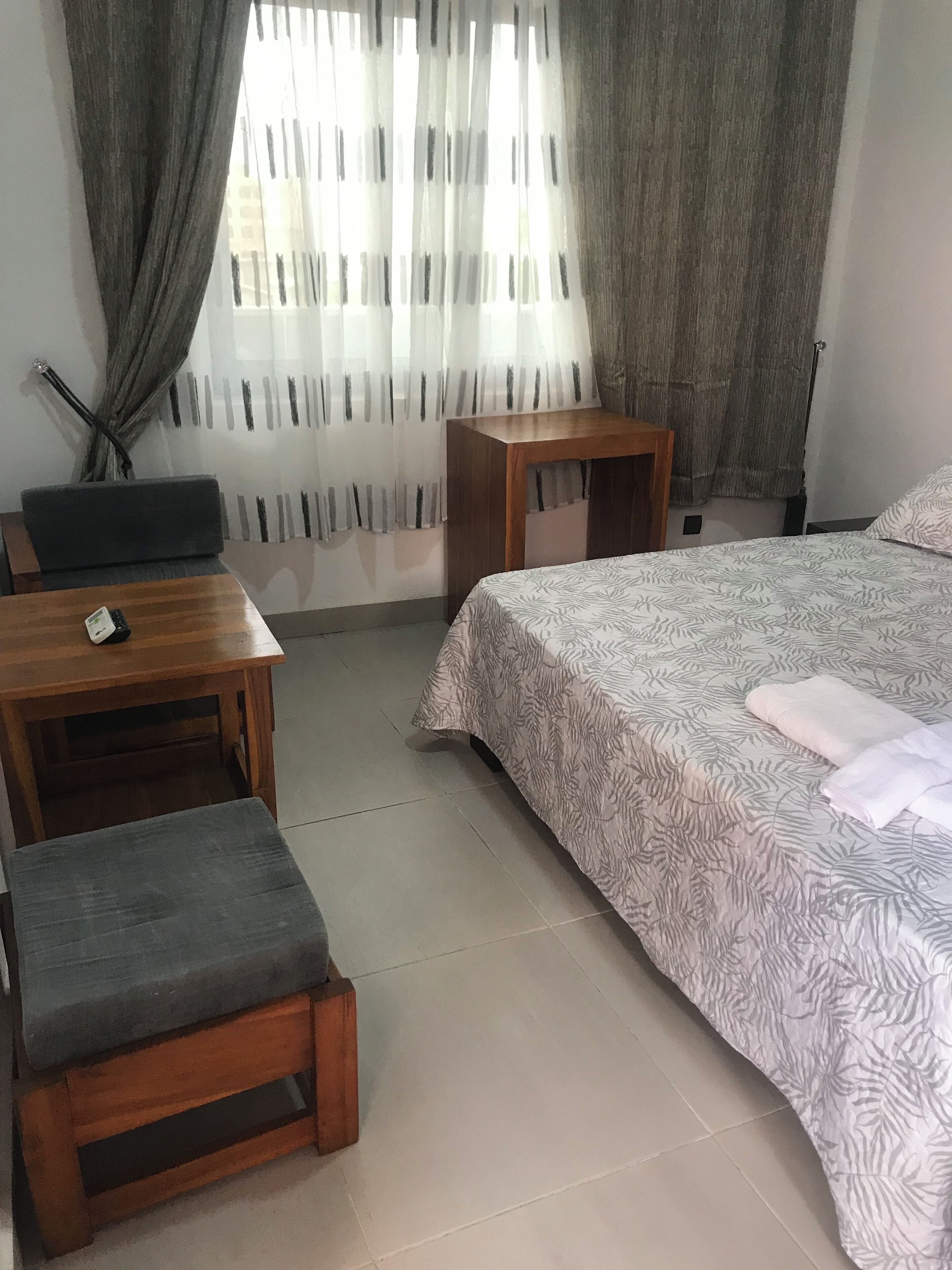 Un dormitorio con una cama, un escritorio y una silla.