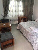 Un dormitorio con una cama, un escritorio y una silla.