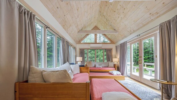 A room with two wooden beds, large windows, and a view of the outdoors. - Quiet Family & Pet Friendly Home! [Owls Nest] (Tremont)
