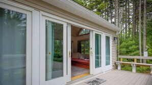 A cabin with a sliding glass door leading to a bedroom with a bed and a window. - Quiet Family & Pet Friendly Home! [Owls Nest] (Tremont)