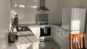 Una cocina moderna con estufa, horno y refrigerador.