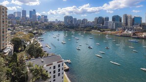 Un puerto deportivo con numerosas embarcaciones amarradas, rodeado por el horizonte urbano con rascacielos.