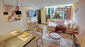 A modern living room with a sofa, chairs, a dining table, and a TV. - Modern apartment in Quito (Quito)