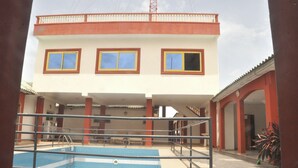 Un edifici amb piscina, diverses finestres i un balcó.