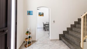 Un couloir menant à une salle à manger, avec un escalier.