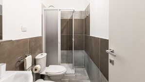 Une salle de bain moderne équipée d’une douche, de toilettes et d  ’un lavabo.