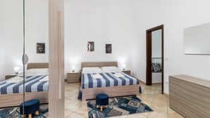 Une chambre avec deux lits, une commode et un miroir.