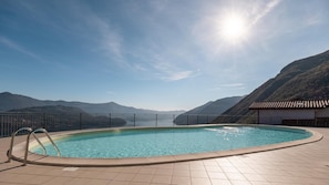 A swimming pool with a view of mountains and a clear sky.