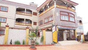 A multi-story building with a patterned facade, balconies, and a sign for "ESPACE ALAFIA KETOU". - Alafia Hotel Ketou (Kétou)