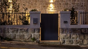 Un edificio de piedra con dos ventanas, una puerta y un pequeño balcón.
