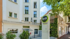 A B&B hotel entrance with a sign, a potted plant, and a building facade. - B&B HOTEL Antibes Juan-les-Pins (Antibes)