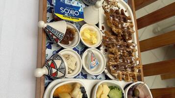 Ett fat med olika sorters mat, inklusive bröd, ost, frukt och tillbehör.