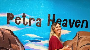 A person standing in front of a mural with the text "Petra Heaven". - Petra Heaven (Wadi Musa)