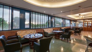 Un'ampia zona relax con una grande finestra, posti a sedere confortevoli e un'area bar.