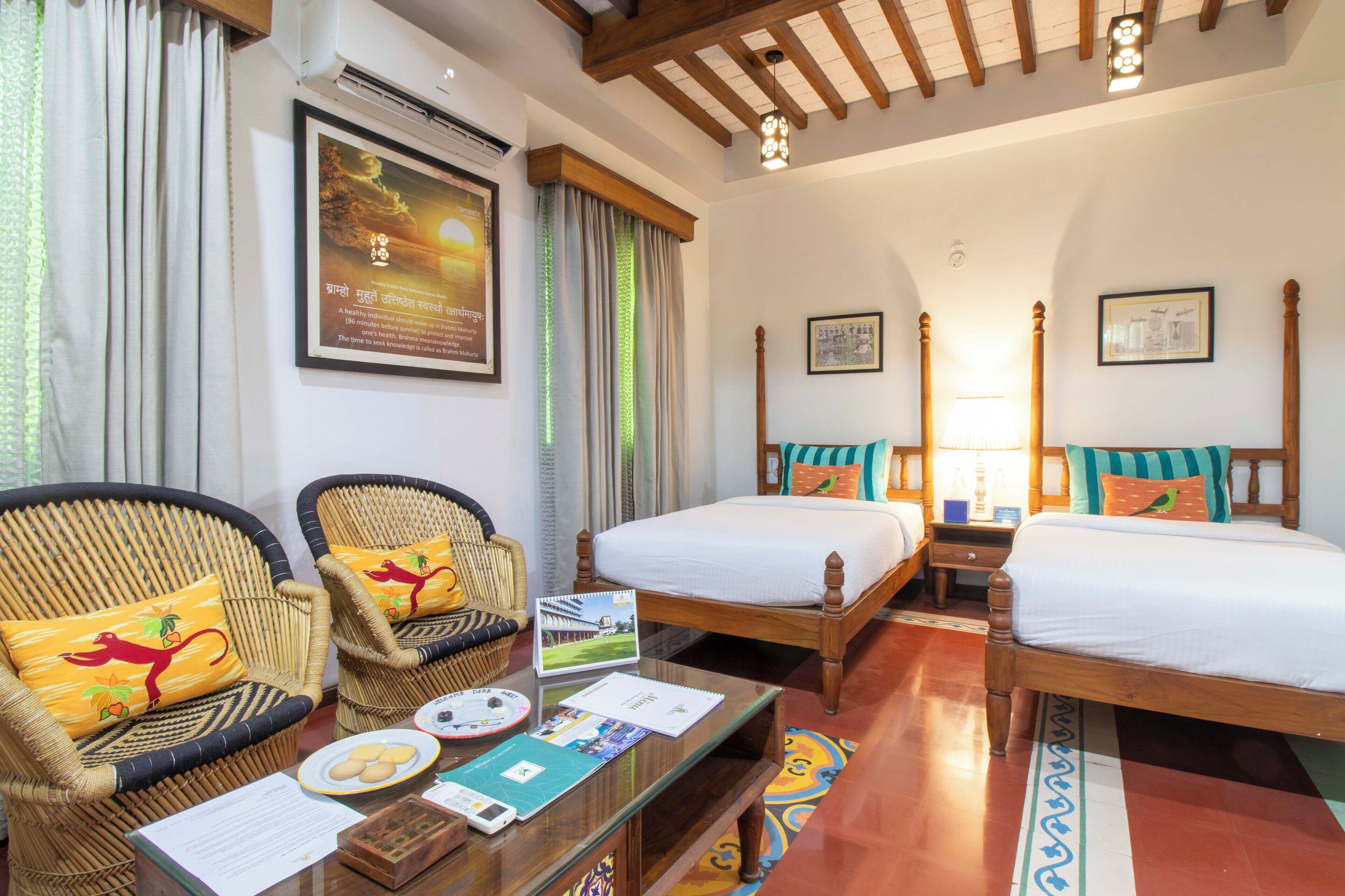 A hotel room with two single beds, a wooden ceiling, a glass coffee table with a menu, and a window with curtains.