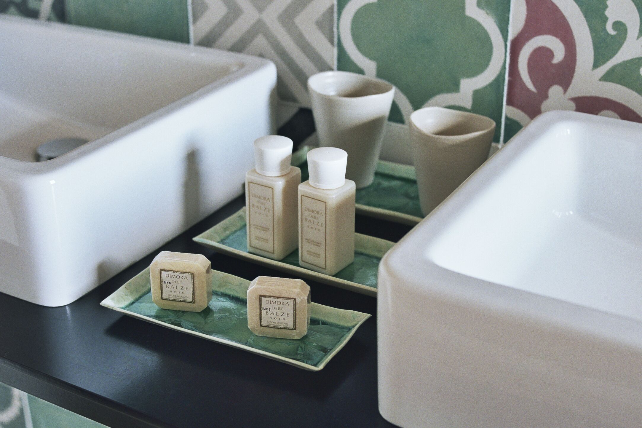 A bathroom with a white bathtub, two sinks, and a vanity with toiletries.