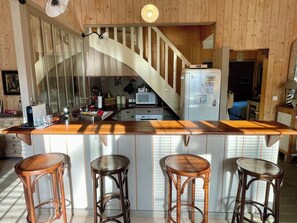 A kitchen with a wooden island, bar stools, and a spiral staircase. - Top located Cap Ferret style villa + Jacuzzi A0379 (Lège-Cap-Ferret)