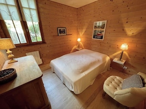 A cozy room with a bed, bedside lamps, a chair, a table with a lamp, and a poster on the wall. - Top located Cap Ferret style villa + Jacuzzi A0379 (Lège-Cap-Ferret)