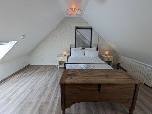 Relax in a cozy retreat with a neatly made bed, bedside tables, and a large window offering a view.
