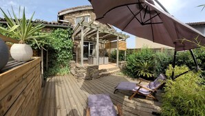 A wooden deck with two lounge chairs and a pergola with a large umbrella. - Countryside cottage with pets allowed, private terrace (Tartaras)