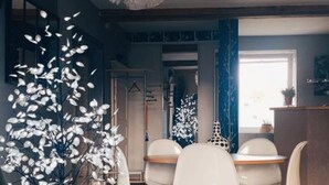 A modern dining area with white chairs and a central table, a decorative white tree sculpture, and a blue curtain. - Countryside cottage with pets allowed, private terrace (Tartaras)
