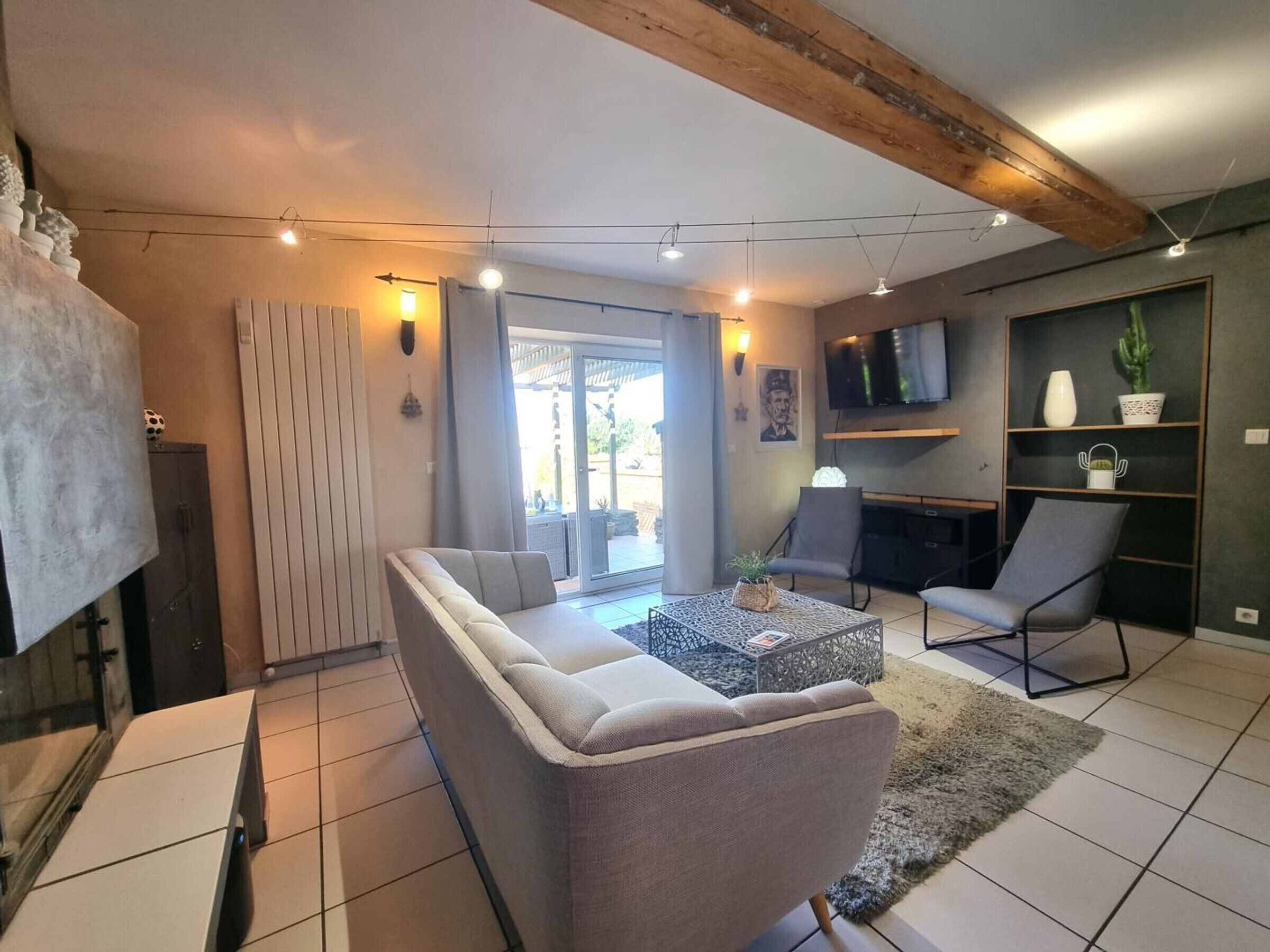 Una sala de estar moderna con un sofá, sillones, una mesa de centro y un televisor.