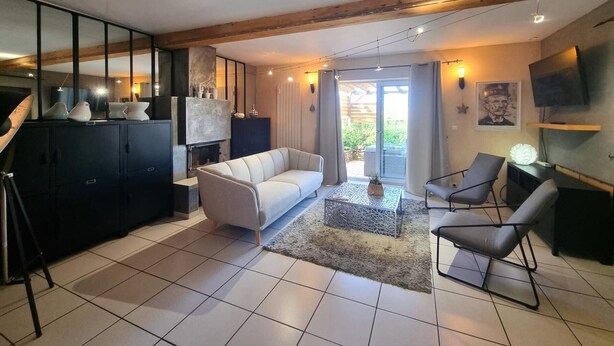 A modern living room with a white sofa, two armchairs, a coffee table, and a fireplace. There is a television mounted on the wall and a large window with curtains. - Countryside cottage with pets allowed, private terrace (Tartaras)
